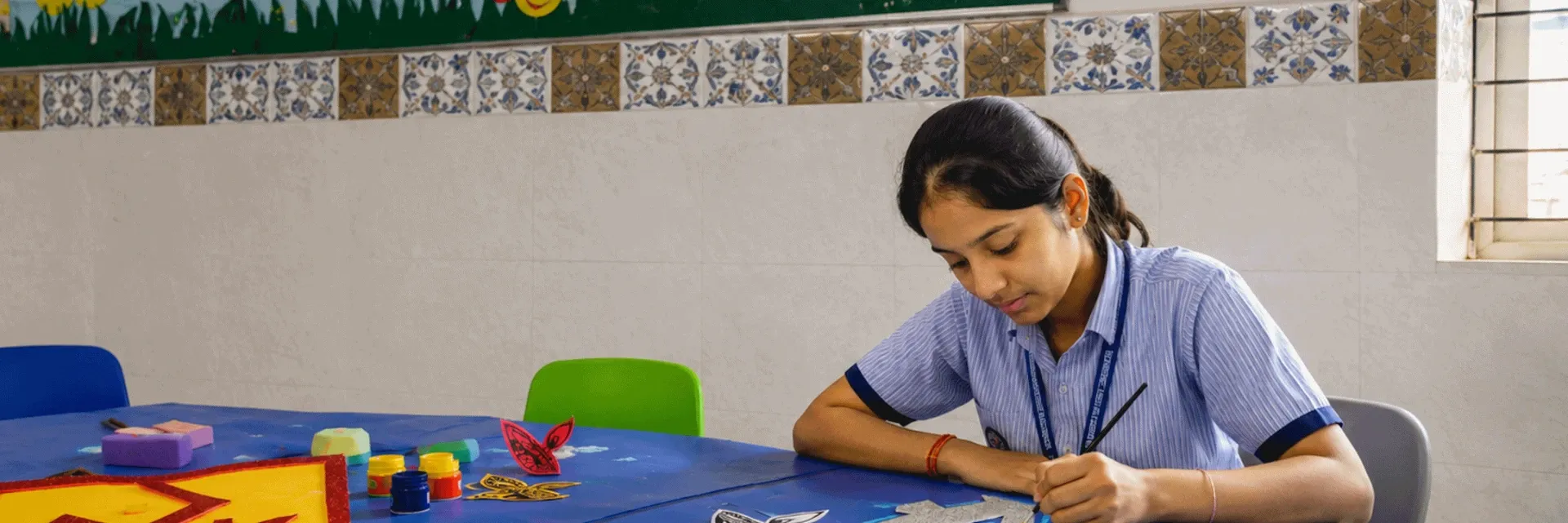 A student painting a craft cut-out in the art room at St. Teresa School