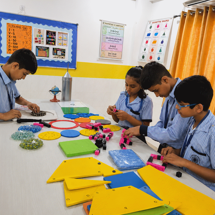 Students exploring geometric shapes and maths manipulatives on a lab table
