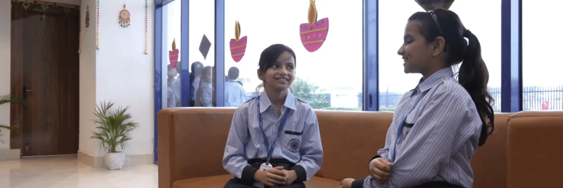 Two students talking together in the school reception area